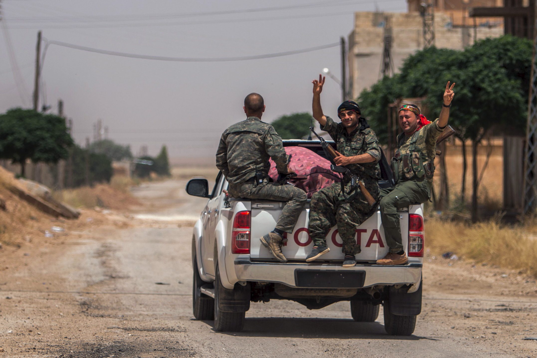 ypg-fighters-gesture-as-they-travel-through-the-town-of-al-mabroukah